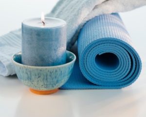 Yoga mat with candle and towel