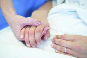 Nurse holding patient's hand
