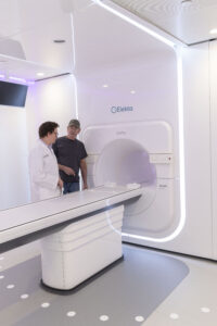 Timmie O'Pry (right) speaks with Dr. Konstantin Kovtun (left) in the suite housing the Elekta Unity treatment system at Mary Bird Perkins Cancer Center in Baton Rouge